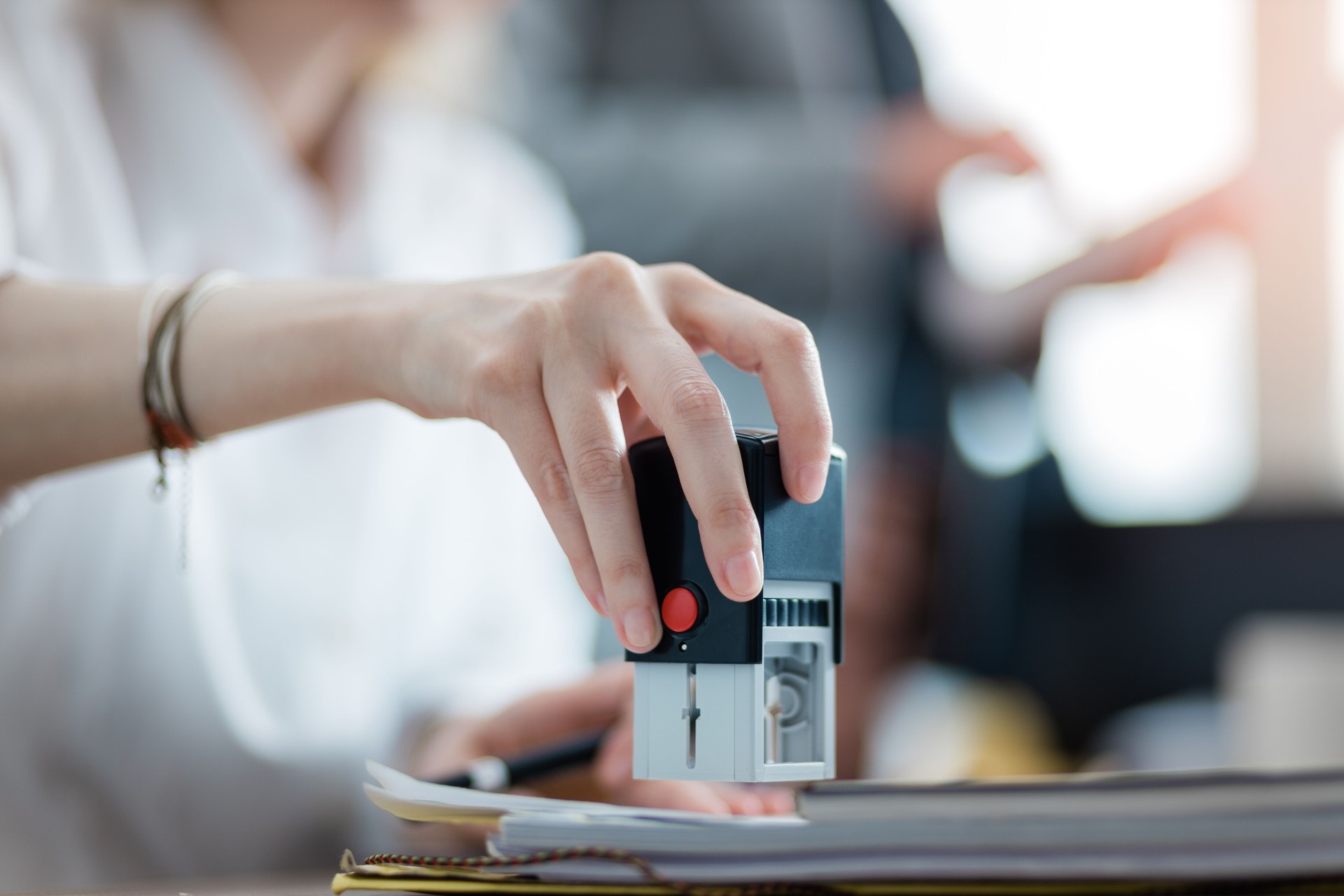 Young businesswoman stamping a document in the office